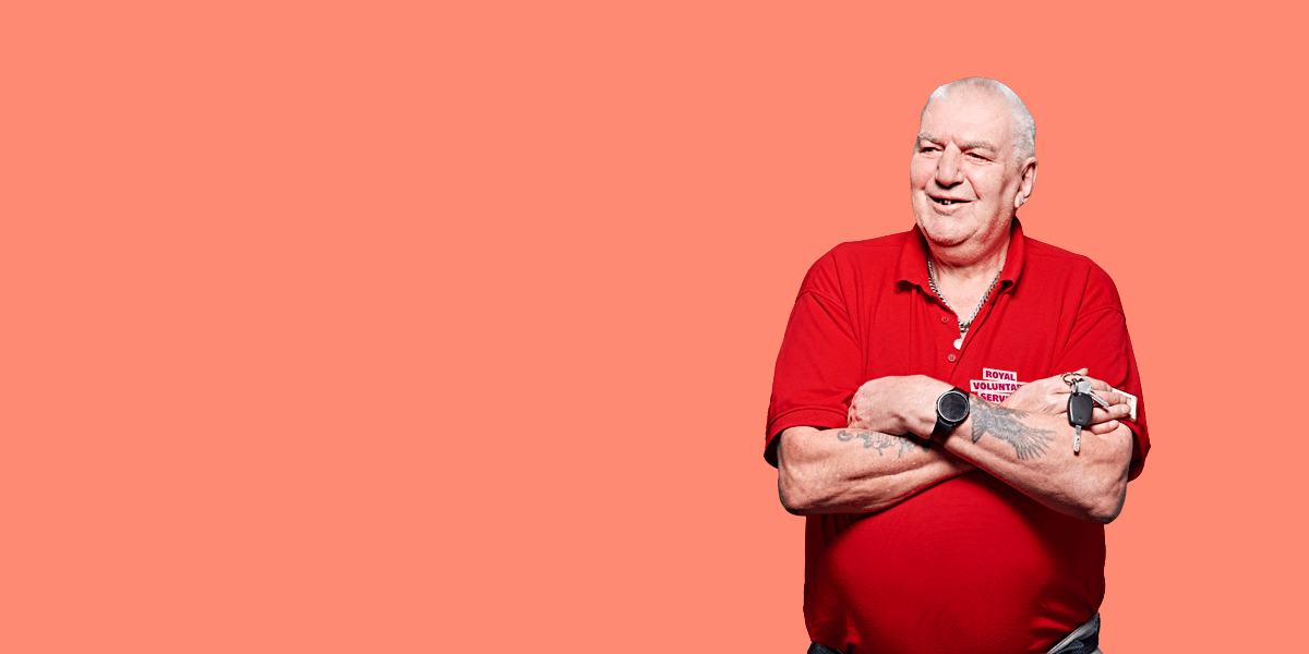 Portrait of volunteer Jonathan against a light orange background 