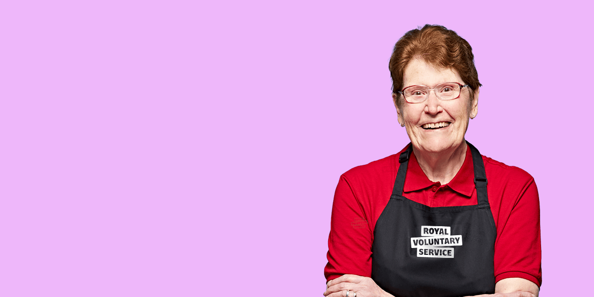 Portrait of volunteer Betty against an lilac background 