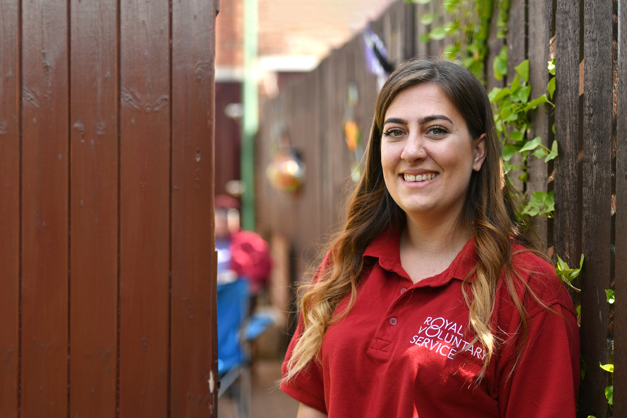 A volunteer walking out of a wooden gate 